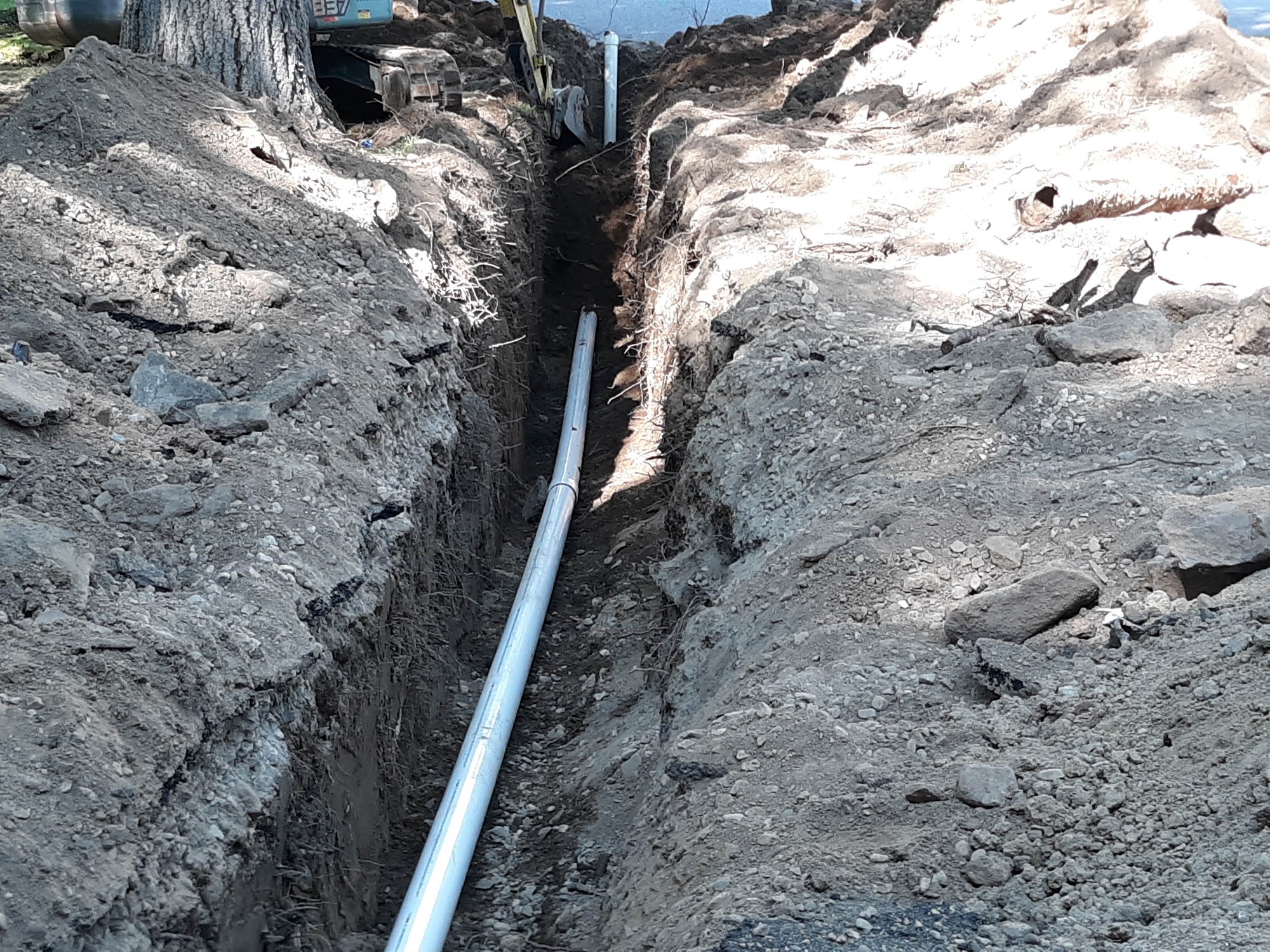 Deep sewer line trench with new PVC pipe installed