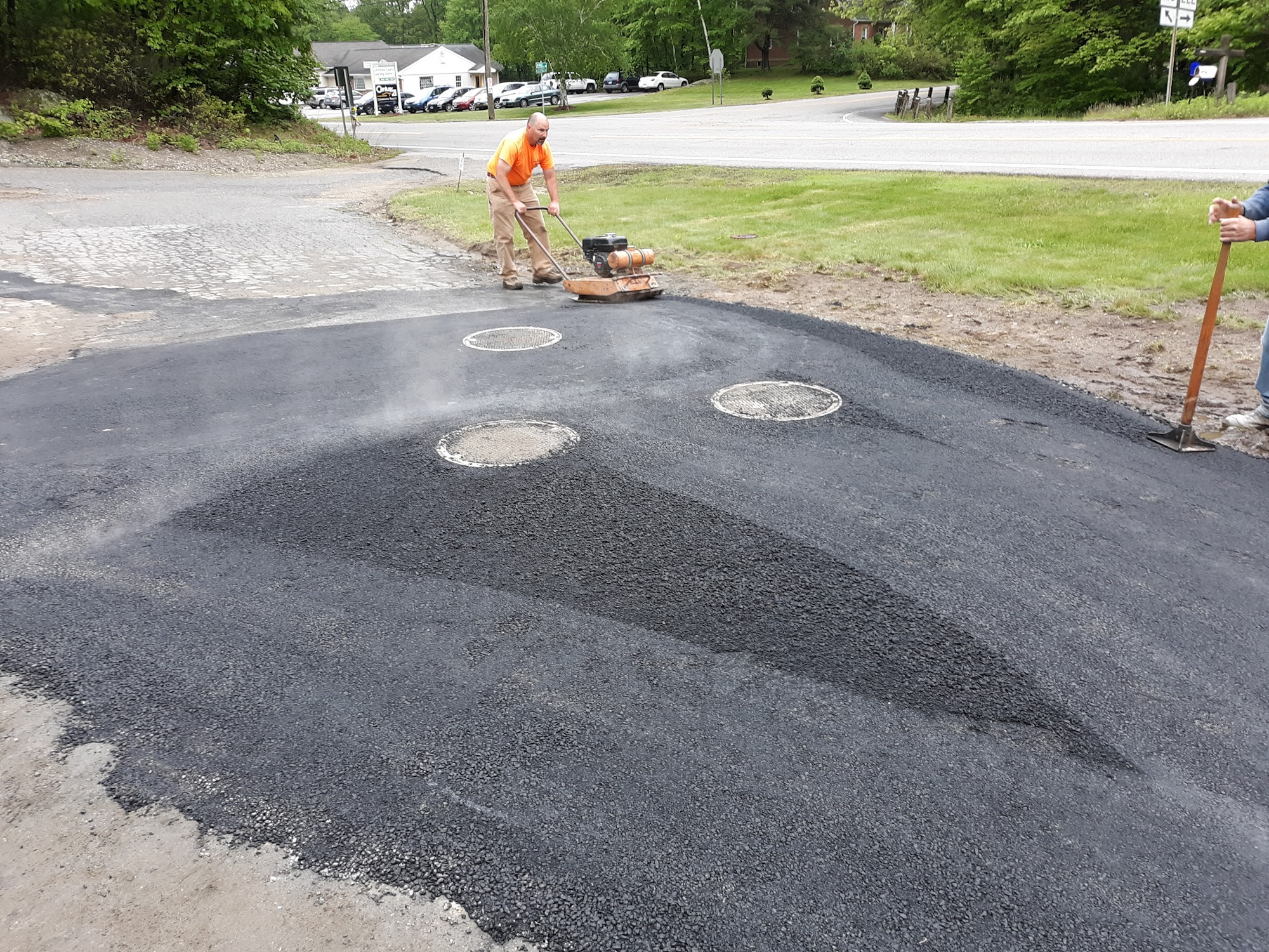 Worker compacting soil after pipe installation